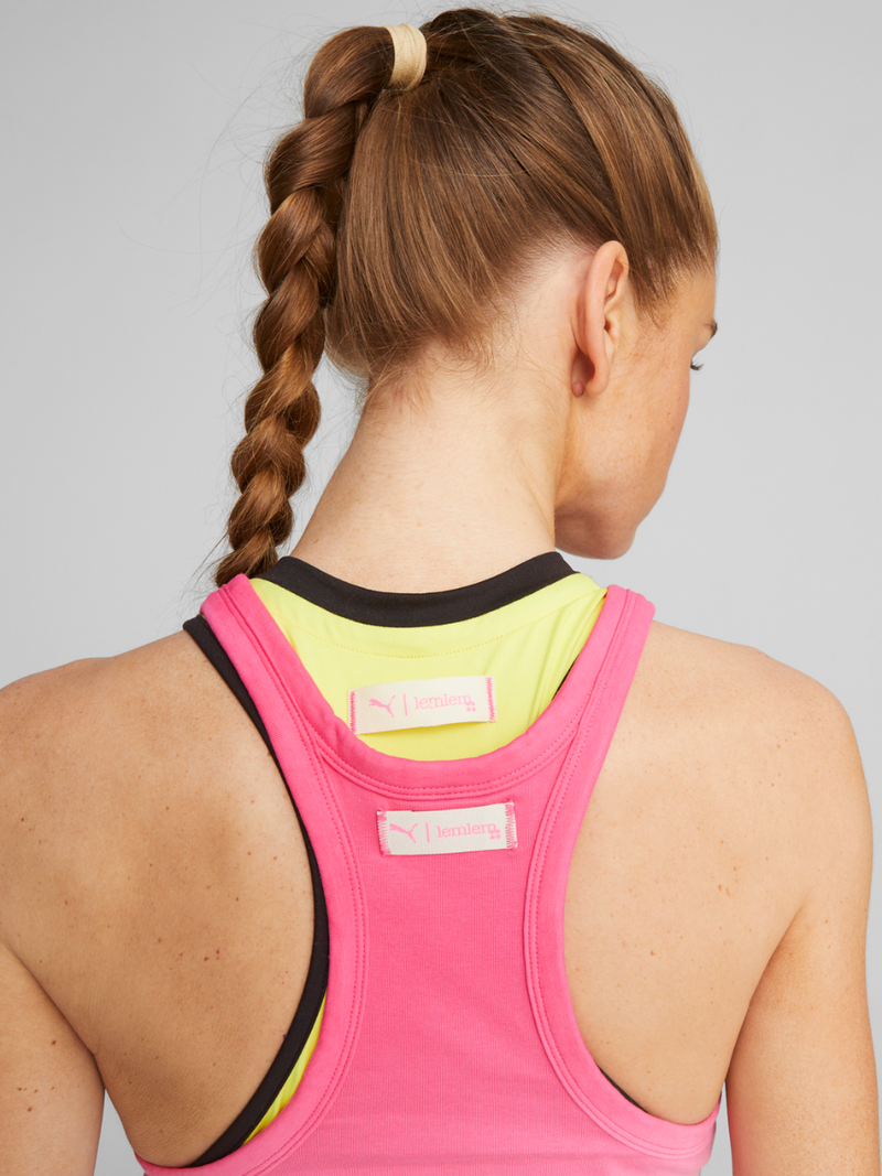 Back View of a Woman standing wearing Puma x lemlem Crop Tank in Frosty Pink Gradient color and Puma x lemlem Crop Tank in Yellow Burst Color