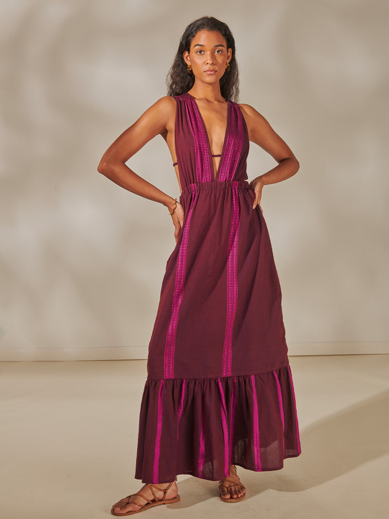 Woman Standing Wearing Lelisa V Neck Dress featuring rich, luxurious burgundy tones with hints of magenta.