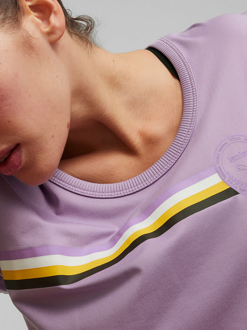 Close Up on a Woman Standing Wearing Puma x lemlem Tee in Vivid Violet Color featuring color stripe detail on the front