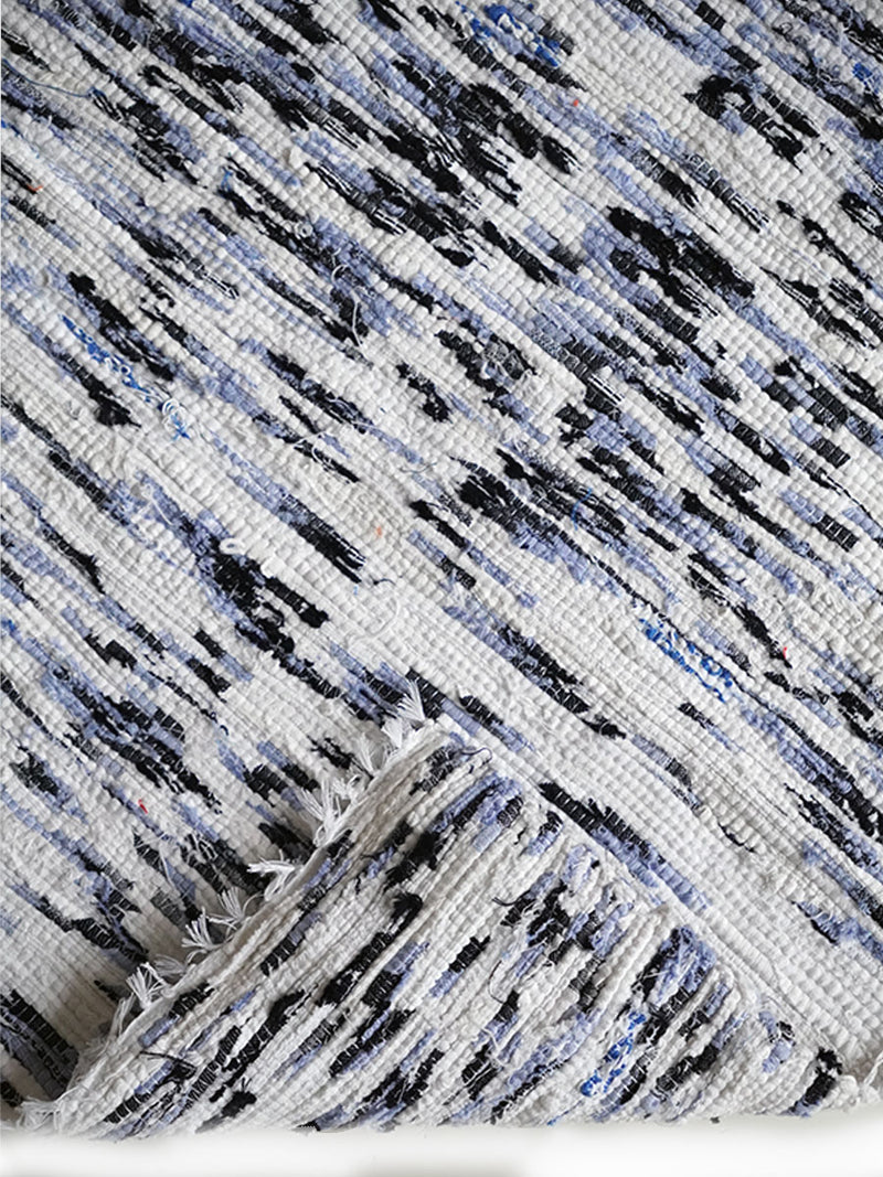 Product Close Up Shot of a Folded Rug Featuring White, Blue and Black Colors