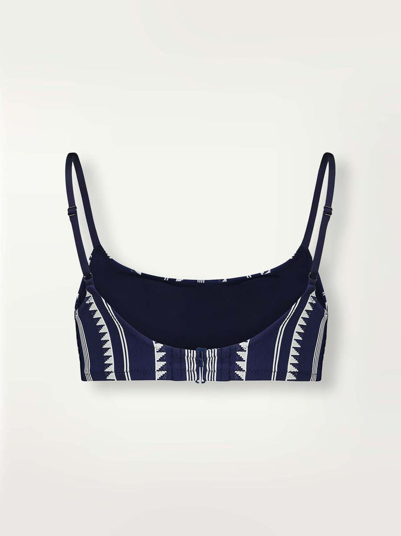 Product shot back view of a navy Nunu bralette swim top with white triangles and stripes