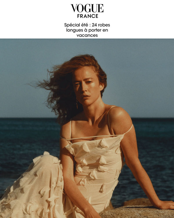 Cover of Vogue France Article featuring a woman sitting on the beach wearing strap dress in cream color