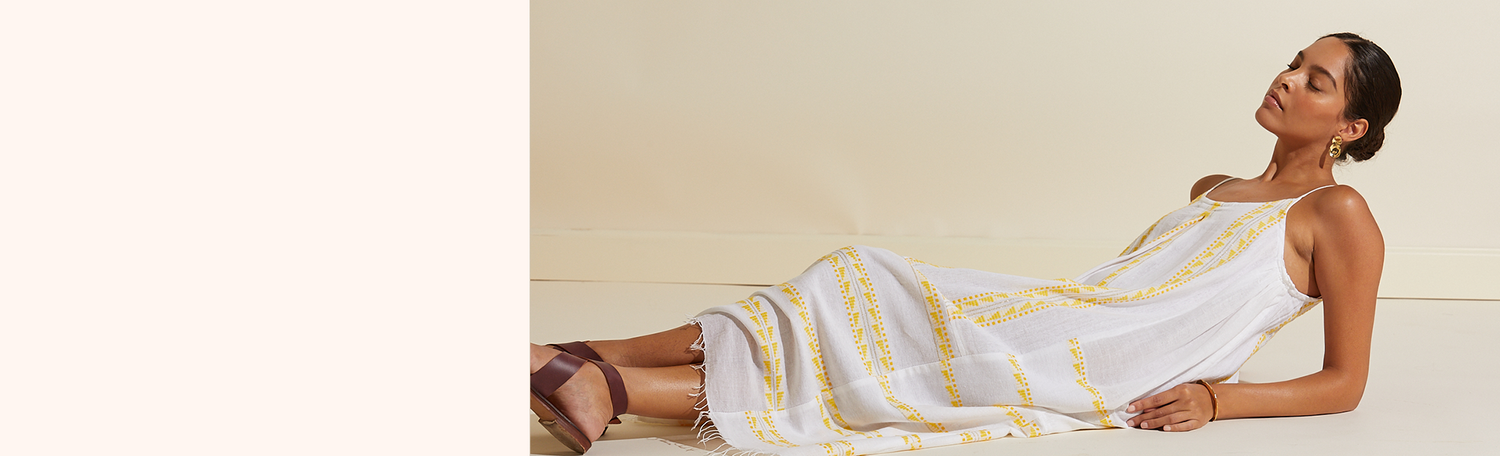 Woman lying on the floor with her legs crossed wearing the Abeba Slip dress