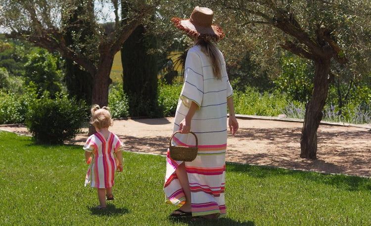 Woman Walking with her little daugther wearing lemlem handwoven dresses