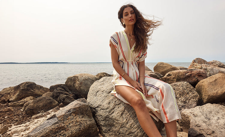 Woman Standing wearing lemlem handwoven button up dress featuring stripe pattern and matching bandeau top and high waist bottom