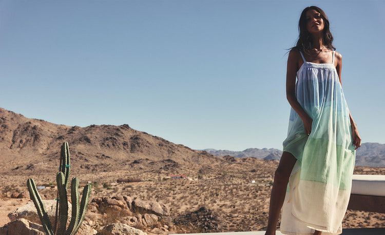 Liya Kebede sitting wearing lemlem handwoven caftan featuring bold and bright tibeb pattern in multiple colors
