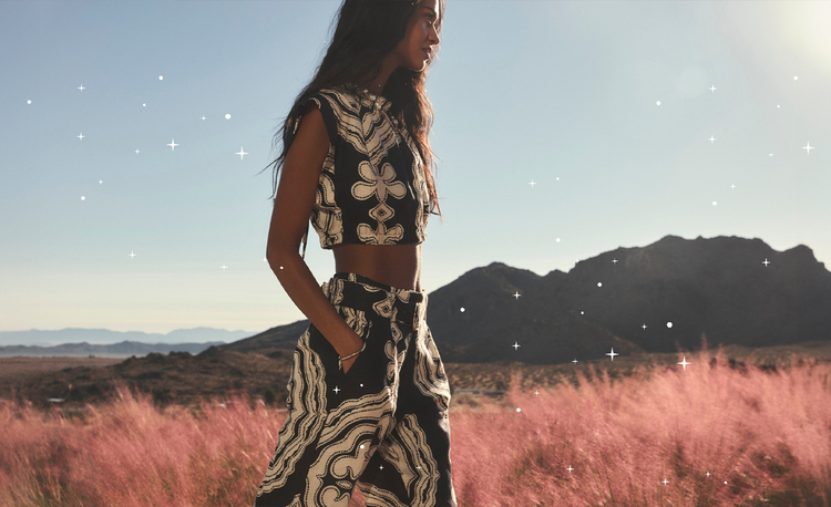 Woman walking in a garden wearing a black & cream matching linen pants set