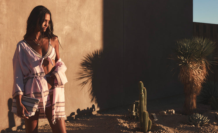 Close up on woman's hands holding beri magenta pouch featuring bright magenta color and wearing a matching scrunchie   