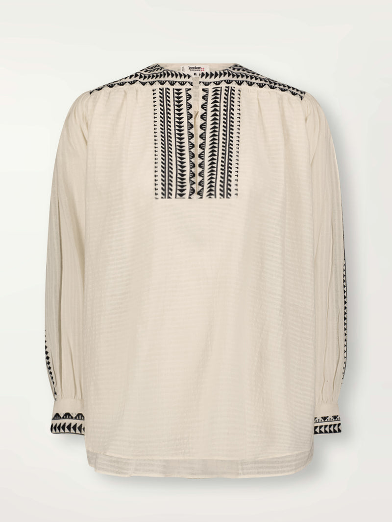 Product Front Shot of Dera Blouse featuring intricate black Tibeb bands on a textured vanilla background.
