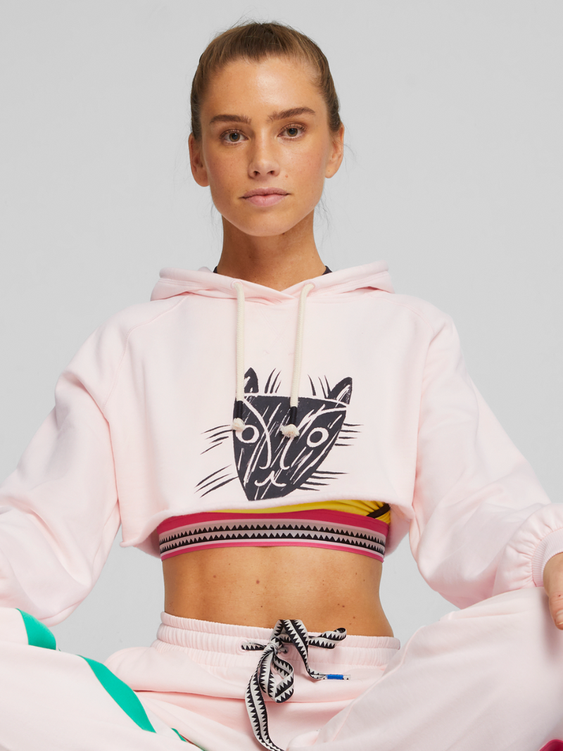 Woman exercising wearing Puma x lemlem Cropped Long Sleeve Training Tee featuring hand sketched Puma logo, puma x lemlem Tank Top and puma x lemlem Joggers in Frosty Pink Color