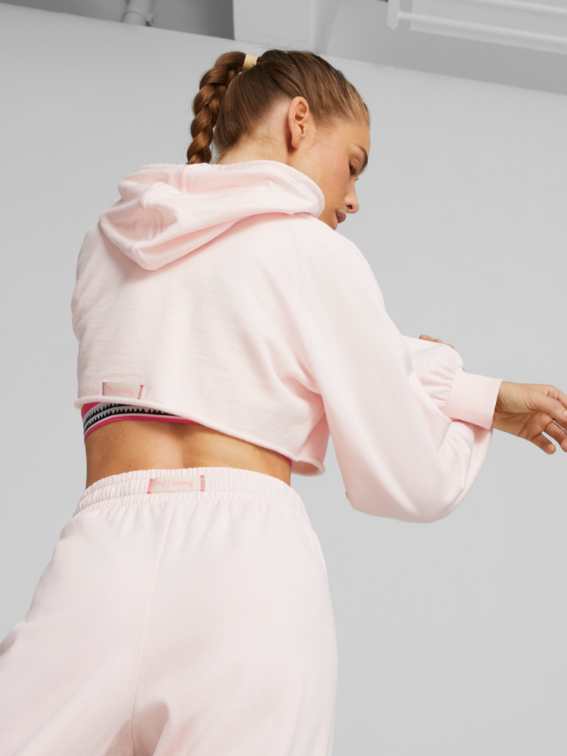 Back view of a Woman exercising wearing Puma x lemlem Cropped Long Sleeve Training Tee featuring hand sketched Puma logo and puma x lemlem Tank Top in frosty pink color
