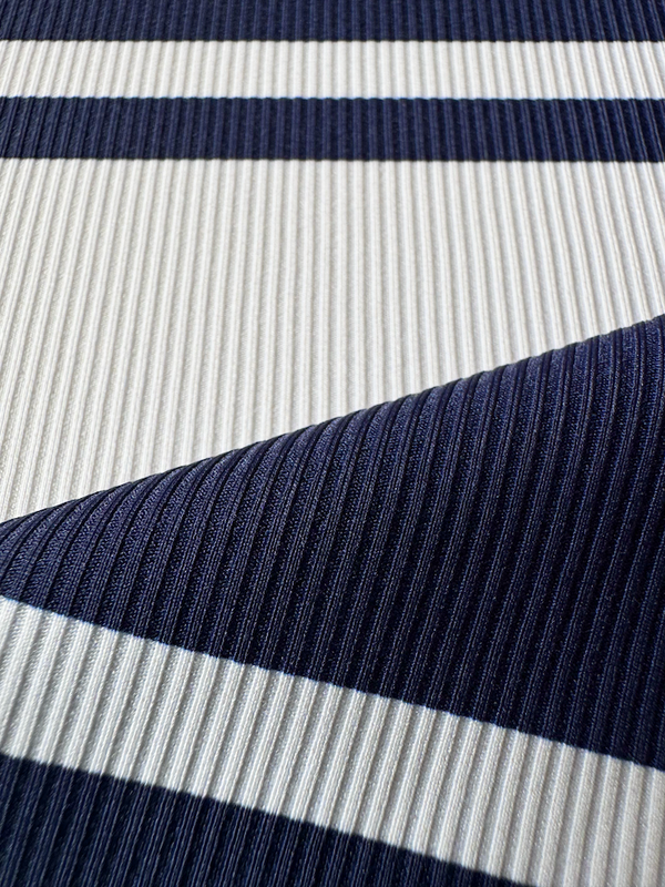 Close up on lemlem Ayele Navy Swim fabric featuring bold two-tone stripes in white and classic navy, printed on soft ribbed fabric.