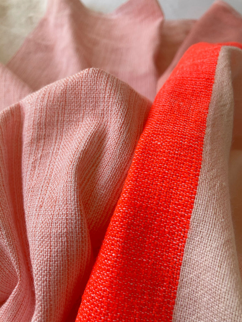 Close Up on Ayele Blush Fabric Featuring asymmetric color block details in tan and blush colors highlighted with bright orange on the soft cream background.