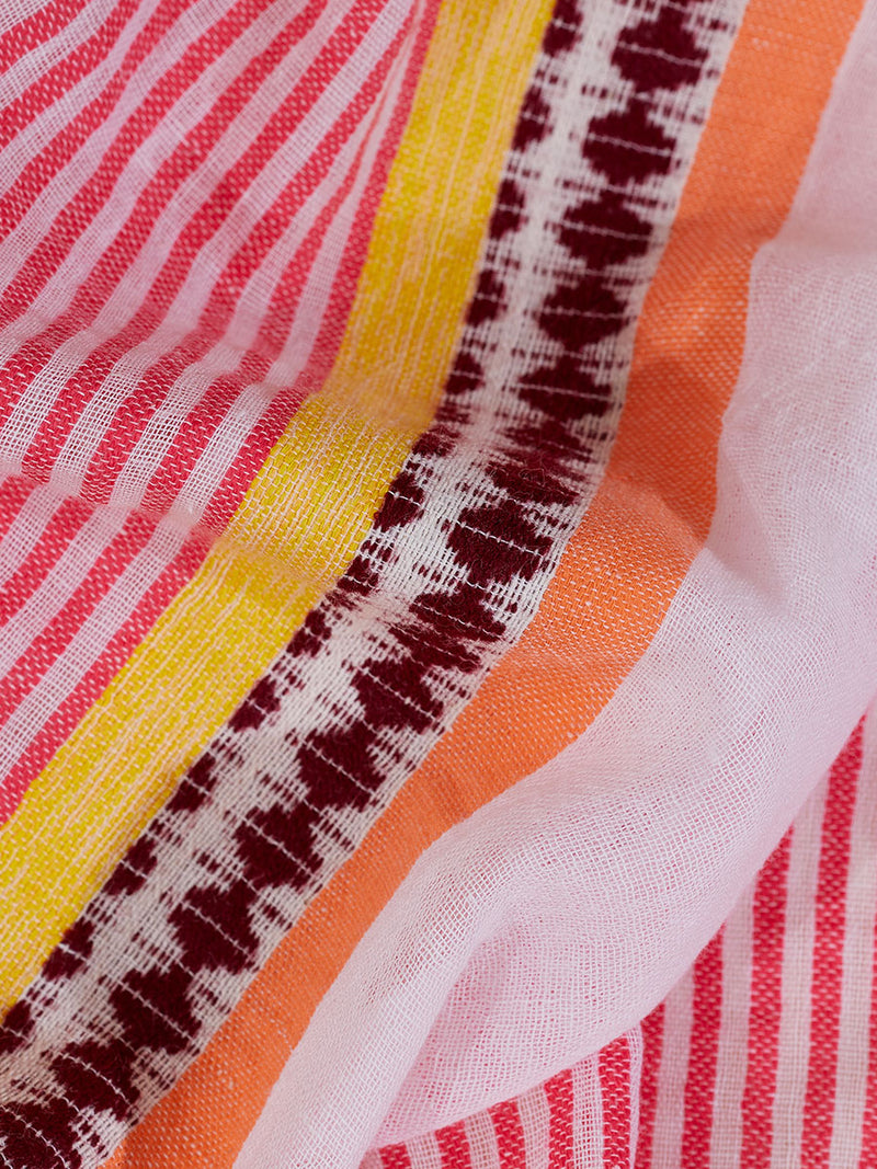 Close up on the fabric of the Cirq Cascade Dress featuring pink, orange and yellow stripes and signature Tibeb design in burgundy bands.