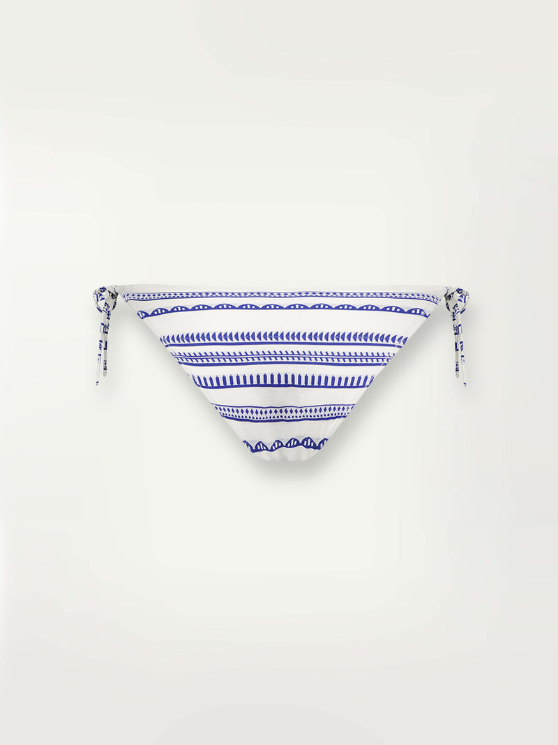 Product shot of the back the Yani String Bikini Bottom featuring blue tibeb diamond design bands on a textured seersucker white background.  