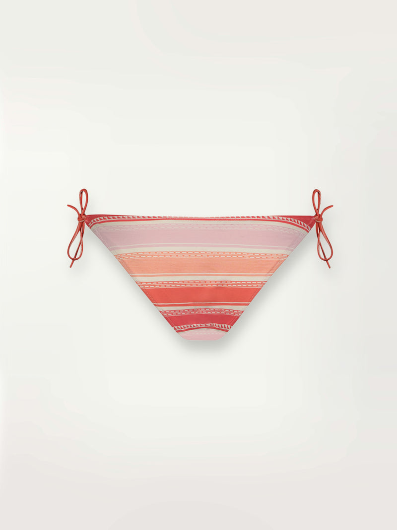 Product shot of the back the Eshal String Bikini Bottom featuring white doted stripes with gradiant orange and tangerine bands on a lilac and white background.