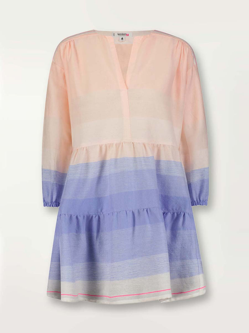 Product shot of the Jelba Popover Dress featuring gradient color block design of nine shades of soft pink and blues highlighted by a bright pink mini stripe at the edge of the dress.
