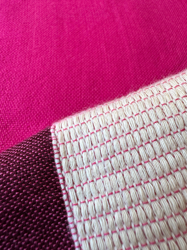 close up on lemlem betami cherry fabric featuring a striking color-block combination of vivid magenta, scarlet, and burgundy colors.