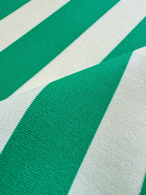 Close up on lemlem Chireti Green swim fabric featuring classic cabana stripe in classic green, accented by soft ivory.