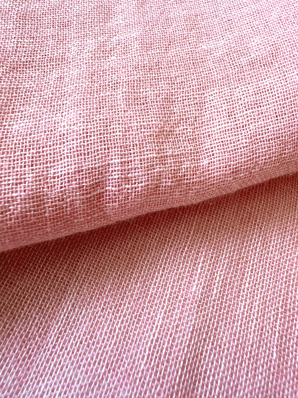 Close up on sheer lemlem fabric in soft rose color
