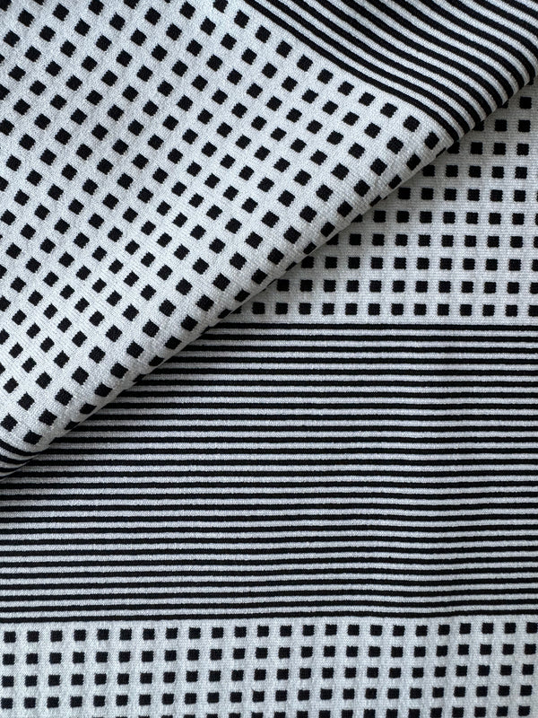 Close up on lemlem Semira Vanilla Swim Fabric featuring archive signature handwoven Semira patter in black and ivory colors
