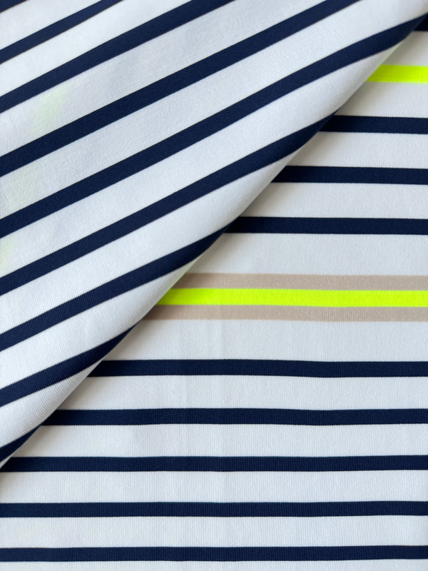 Close up on  lemlem Bahar Cream Swim Fabric featuring an ivory ground with navy stripes, accented by khaki and citron hues
