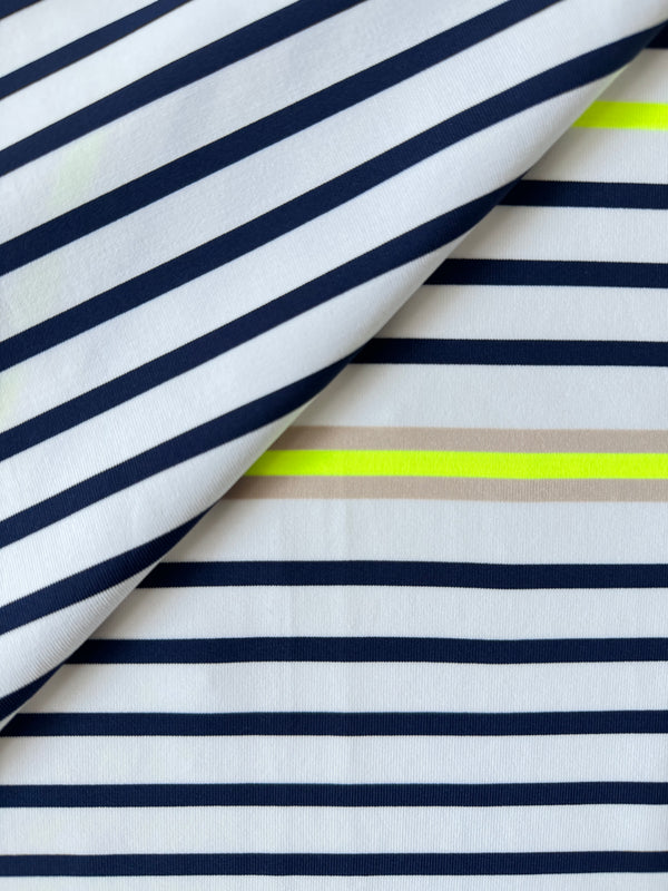 Close up on lemlem Bahar Cream Swim Fabric featuring an ivory ground with navy stripes, accented by khaki and citron hues