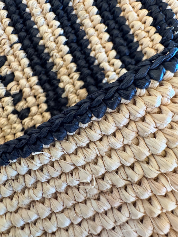 Close-up of the hand-crocheted lemlem raffia bag with black and beige pattern