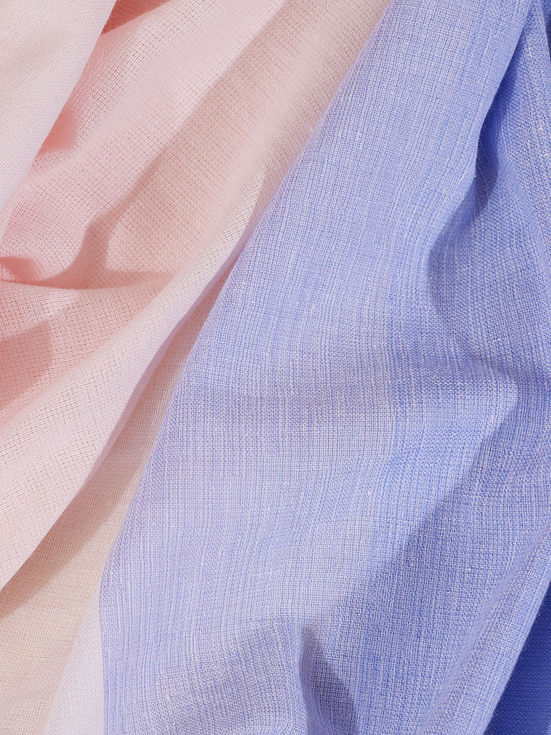 Close up on the fabric of the Jelba Short Plunge Neck Dress featuring gradient color block design of nine shades of soft pink and blues highlighted by a bright pink mini stripe at the edge of the dress.