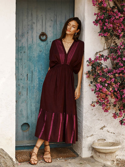 Woman Standing Wearing Leila Plunge Dress featuring rich, luxurious burgundy tones with hints of magenta.
