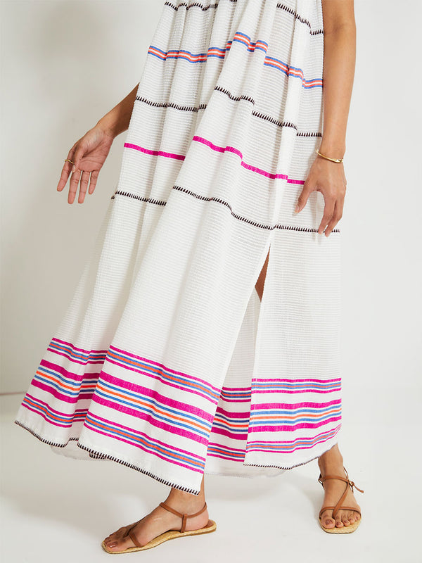 Close up on Woman's legs Standing Wearing lemlem Eda Slip Dress featuring a stripe pattern of bright magenta, blue, and orange on s crispy white background
