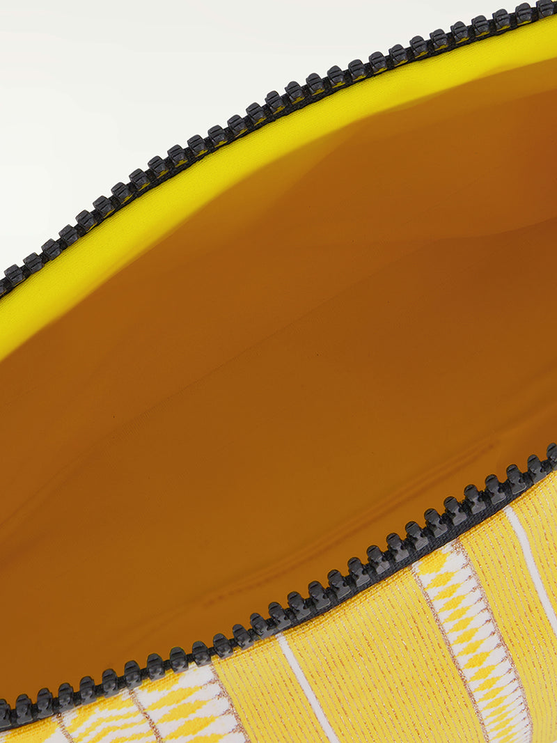 Inside of a yellow travel pouch featuring white vertical graphic stripes and a black zip closure at the top.
