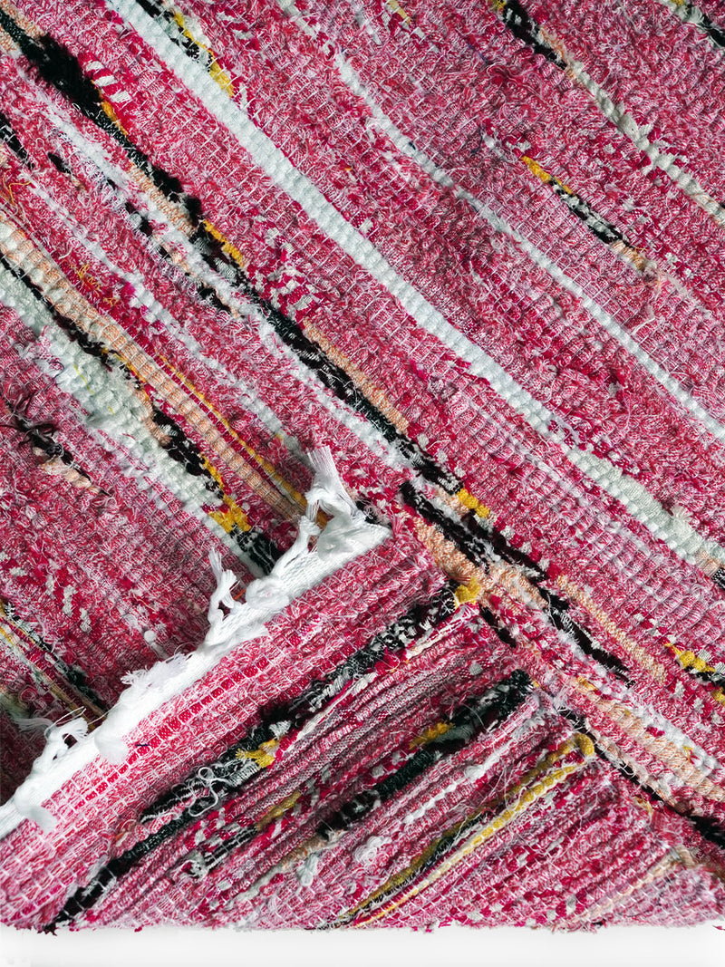Close up on a Folded Neela White Rug Featuring Pink, White, Yellow and Black Colors