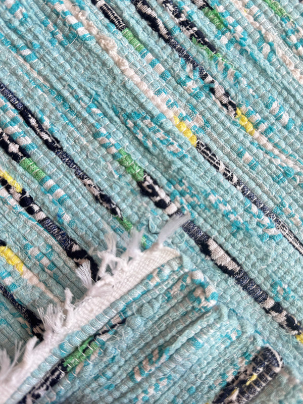 Close-up of a textured fabric of lemlem upcycled handwoven MESFIN Rug 