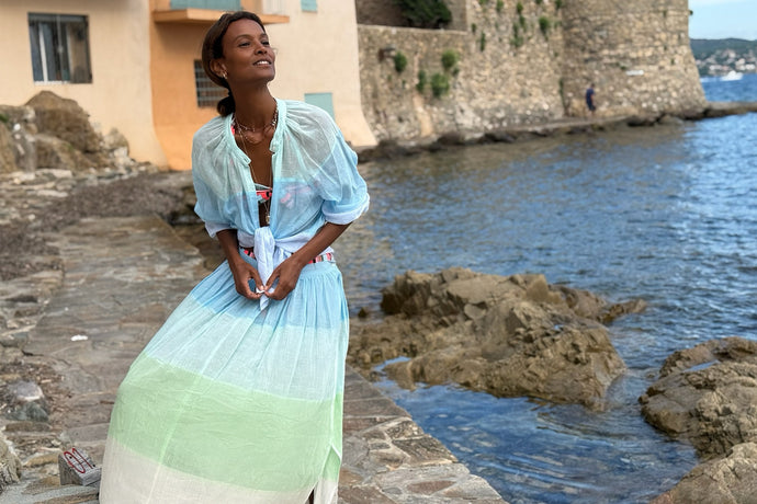 Liya Kebede standing wearing lemlem MITA Blouse and FREYE Skirt featuring color block pattern in mint, bue and cream colors and gauze fabric