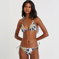 Woman Standing wearing lemlem MALIA Triangle Top and REKKA String Bottom featuring floral inspired pattern 