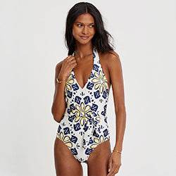 Woman standing wearing lemlem LIDYA One Piece swimsuit featuring floral print 