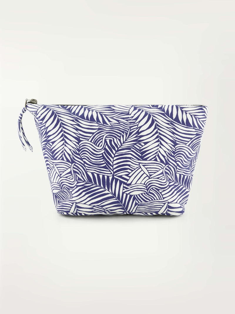 Product picture of a blue travel pouch featuring all over palm leaf pattern and a black zip closure at the top.