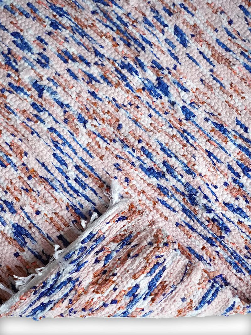 Сlose Up Product Shot of a Folded Sky Blue Rug Featuring Light Pink and Blue Colors