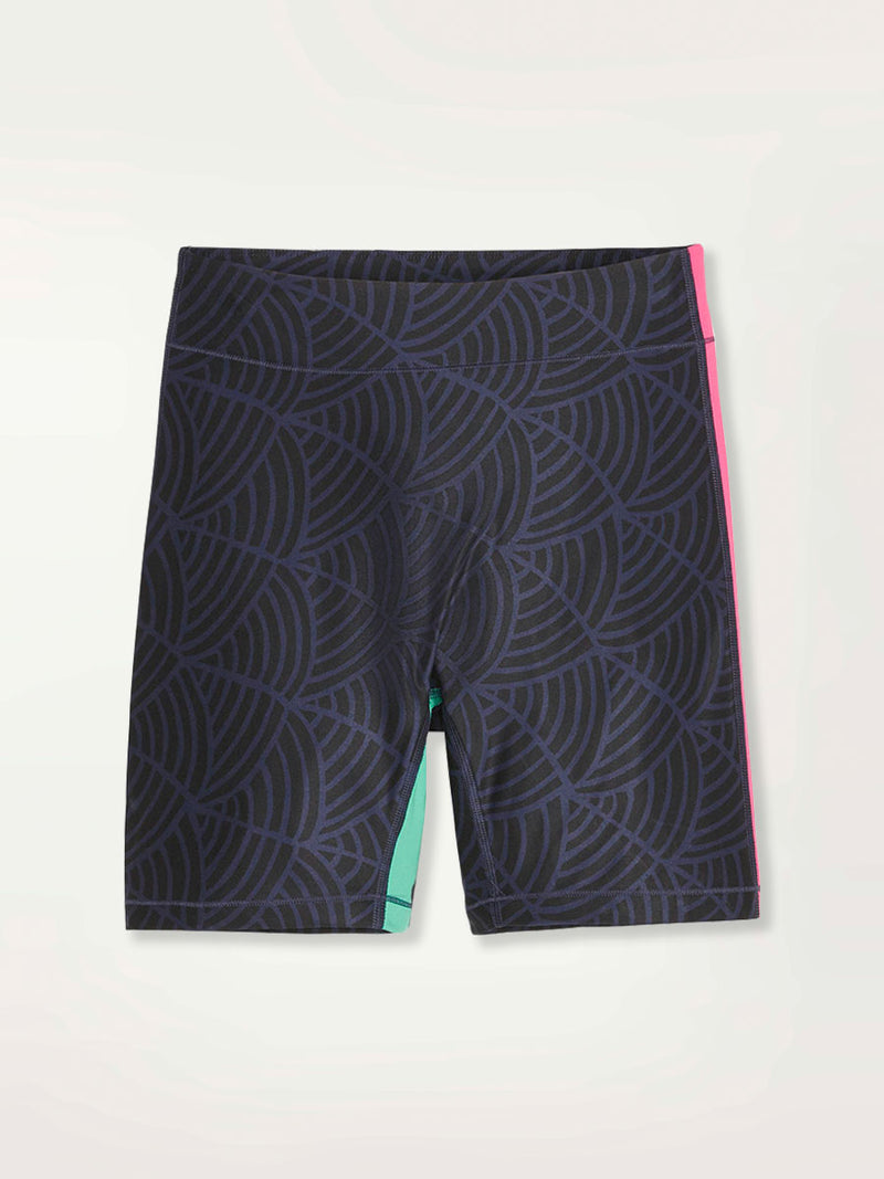 Product  Shot of a Puma x lemlem bike shorts featuring hand sketched scallop print in Navy and Black colors and color block side stripes in bright pink and turquoise colors