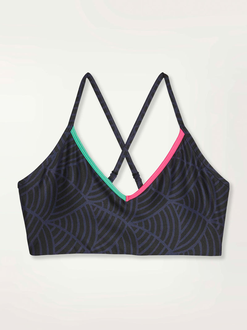 Product Shot of a Puma x lemlem low impact bra featuring hand sketched scallop print in Navy and Black colors and color block side stripes in bright pink and turquoise colors