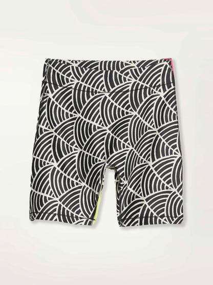 Product Shot of a Puma x lemlem bike shorts featuring hand sketched scallop print in Ghost Pepper and Black colors and color block side stripes in bright pink and green colors