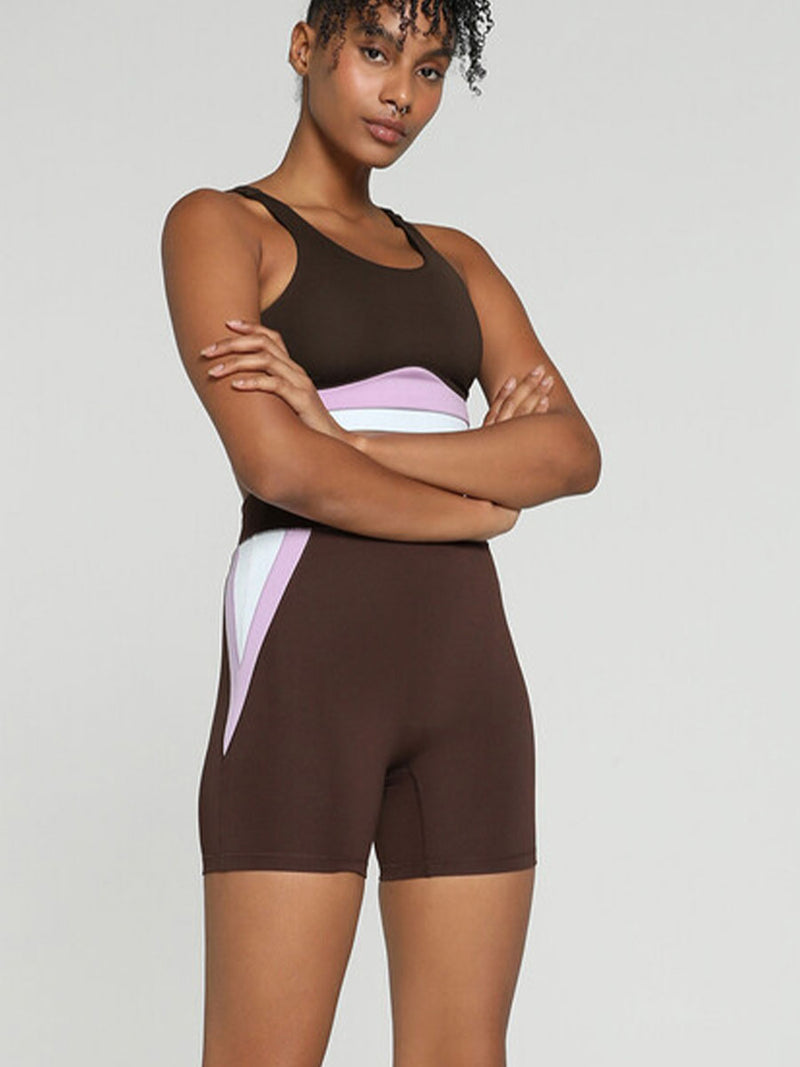 Woman Standing Wearing Puma x lemlem Biker Shorts Featuring Dark Chocolate Color and color block details on hips in Violet and White Colors and a matching tank top