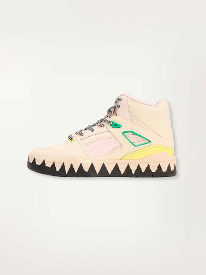 Product shot of a Puma x lemlem Slipstream Mid Sneakers featuring frosty pink, ghost pepper colors, yellow and green color block details, handsketched puma cat logo and signature lemlem Tibeb Pattern