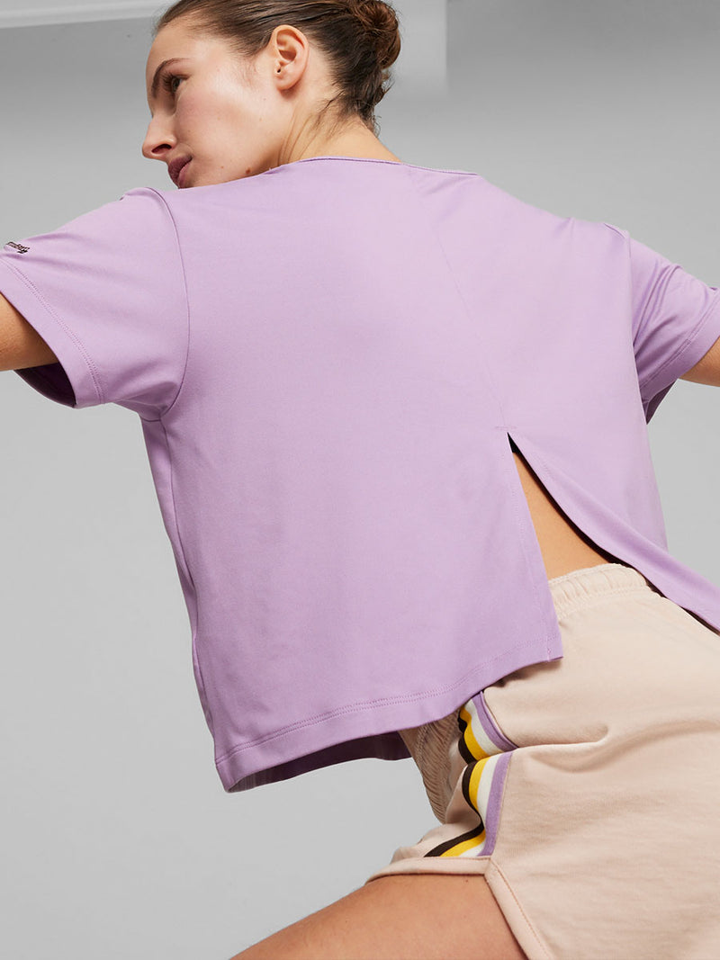 Side View of a Woman Exercising  Wearing Puma x lemlem Tee in Vivid Violet Color featuring color stripe detail on the front