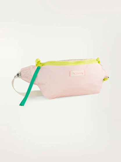 Product Front Shot of a lemlem waist bag in frosty pink color featuring color block zipper and lemlem triangle pattern strap