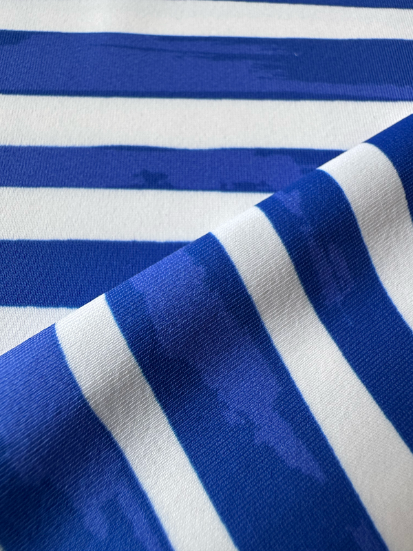 close up on lemlem fabric  featuring an exclusive in-house designed painted-effect stripe print in a vibrant, dazzling blue on a white background