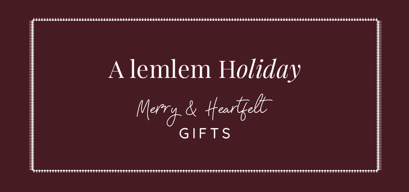 Holiday gift card with 'A lemlem Holiday Merry & Heartfelt GIFTS' text on a dark red background.