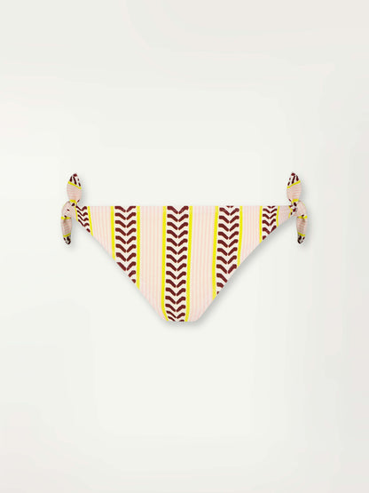 Product Front Shot of a Lucy Side Tie Bottom featuring delicate pink stripes with a bold chevron patterned ribbon, along with muted hues of pink, burgundy, and a bright citrus hue.