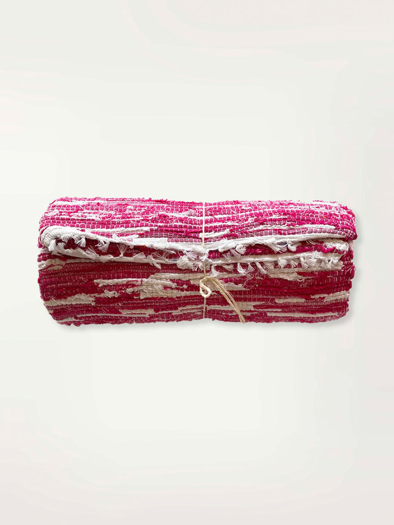 Product Shot of rolled up Magenta rug featuring Magenta and White Colors